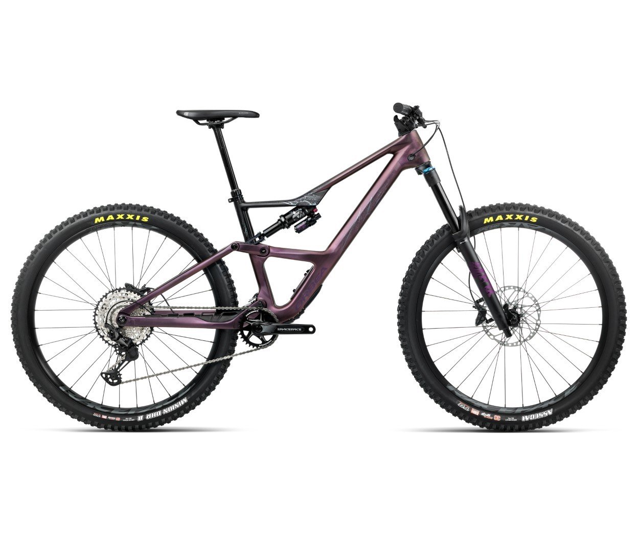 Vélo de montagne coloré prêt pour faire du vélo en forêt, cadre robuste, suspension avant, roues larges et pneus tout-terrain, composants et transmission visibles.
